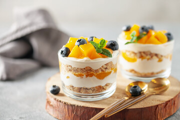 Delicious mango float cake in glasses on wooden board. Filipino sweet cuisine