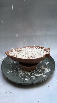Grated coconut falling on a milk chocolate Easter egg_vertical.