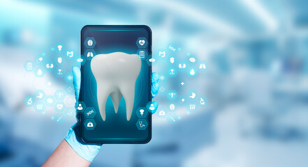 The doctor's hand holds a smartphone displaying a dental health app, highlighting the image of a...