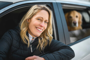 Portrait of happy healthy dog outside in winter season on car. Cute golden retriever