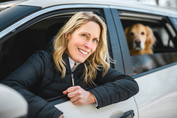 Portrait of happy healthy dog outside in winter season on car. Cute golden retriever