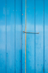 Texture of blue wooden door with metal hook