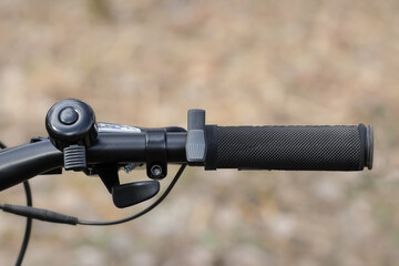 Close-up of the handlebars of an electric bicycle.Throttle button on the e-bike handle.