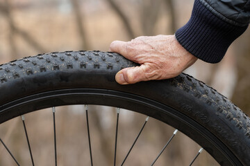Fototapeta premium Bicycle wheel tire close-up.A bicycle tire with a large tread in the dried mud after a ride.