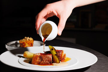 the chef in haute cuisine French restaurant preparing the dish veal meat artichokes on a modern...