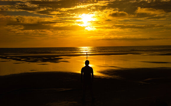 A person on the beach at sunset