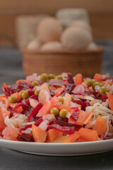 Boiled vegetable salad - beets, potatoes and carrots, green peas, onions, fermented cabbage and cucumbers, . Vinaigrette. Healthy eating. Close-up
