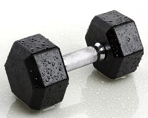 A wet black dumbbell rests on a reflective white surface