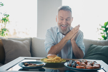 Elderly man excitedly deciding between sushi, fast food, and a dessert at home in a well-lit modern living room