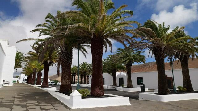 A peaceful view of Plaza San Marcial de Fem&eacute;s in Lanzarote, next to the historic Church of San Marcial del Rubic&oacute;n. A charming square with traditional architecture and a scenic mountain backdrop.