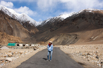 Obraz premium Thai woman travel visit stand and walking for take photo on Pangong lake road with view landscape himalayan mountains range while winter season at Leh Ladakh in Jammu and Kashmir, India
