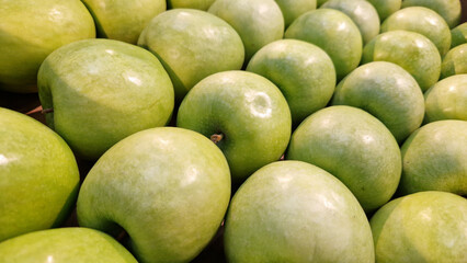 Variety of fresh apples on the supermarket counter. Apples for sale in the supermarket. Ripe juicy apples close-up with selective focus. Fruits. Heap of apples for sale in the store