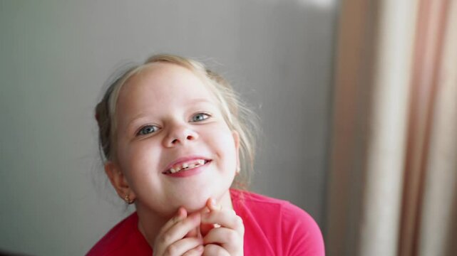 Young girl holding hands together at chest, pleading with determination. Expressing a request and urging someone to buy something. Close-up of persuasive facial expression and focused body language.