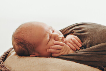 A newborn baby is wrapped in diapers with a wool cap in a basket. Swaddling, maternity hospital, family, ivf, life planning, parenting. A mother's love for her child. Baby food. High quality photo
