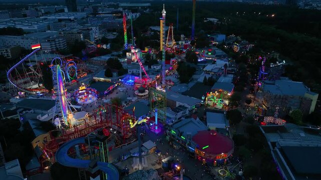 Aerial view fun fair. Twilight time illumination Vienna city famous theme amusement park Prater riverside downtown aerial panorama 4k Austria