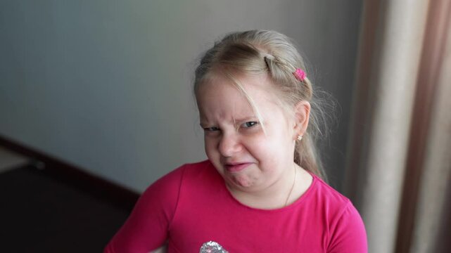 Young girl expressing strong disgust, wrinkling nose, frowning, and making a grimace. Reaction of aversion and displeasure to something unpleasant. Negative emotions, rejection, scornful expression