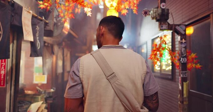 Back, man and travel in Japan for street food, journey and tourism in Omoide Yokocho at night. Tourist, walking or traditional kiosks in Tokyo for culture heritage, memory lane or pubs for experience