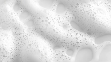 Close-up view of creamy white foam with bubbles, creating a textured surface, ideal for backgrounds in design