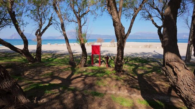 Red fire safety box placed at forest edge near water