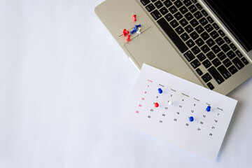 push pin with calendar on laptop