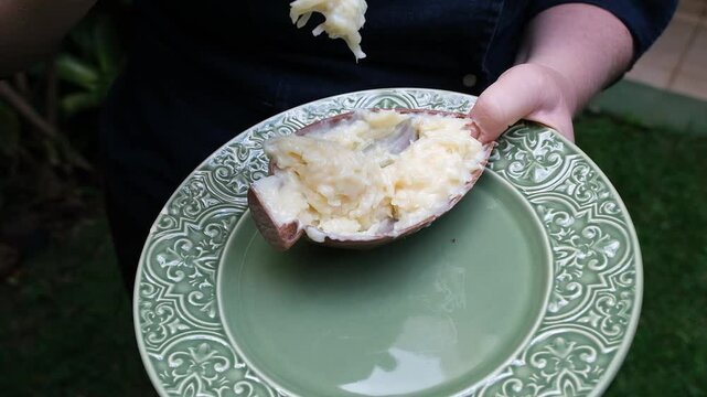 Confectioner dropping creamy coconut fudge filling.