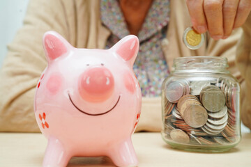 Retired elderly woman counting coins money with piggy bank and worry about monthly expenses and...