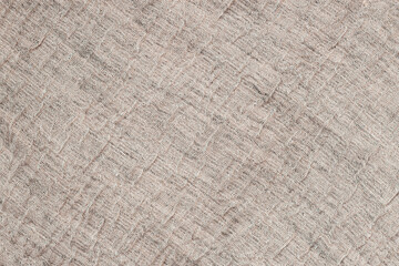 Beige linen fabric texture with folds. Worn linen fabric texture with visible weave and wrinkles. Organic and natural background for rustic and vintage textile designs