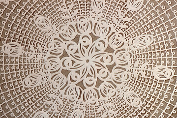 Cream craft lace doily, vintage textured background. Vintage lace doily with intricate cutout patterns on a neutral background. Delicate and classic decorative textile for elegant designs