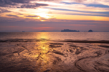tourist watching sunset or sunrise  on beach with seascape and gold lighting sunset sky background