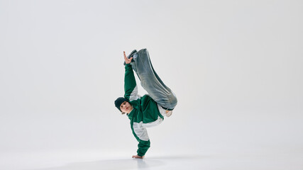 Performer, dressed retro attire, striking dynamic one-handed pose with legs airborne, showcasing...