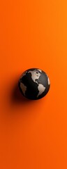 A globe resting against an orange background, symbolizing global themes and connectivity.