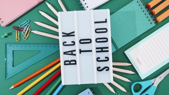 Back to School concept in Stop Motion animation. Words "Back to School" with school supplies on a green background. Stopmotion school preparation, study organization, excitement of a new academic year