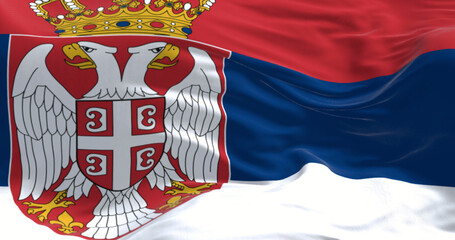 Serbian flag waving close-up with royal coat of arms symbolizing history and heritage