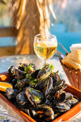 Mussels and white wine in a restaurant with a sea view in oyster farm of Kotor Bay, Montenegro