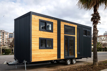 Modern tiny house on wheels with wooden exterior.