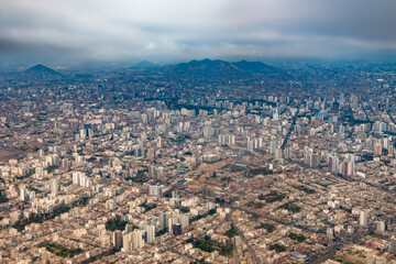 Obraz premium A sweeping aerial perspective highlights the vast urban sprawl of Lima, where modern architecture coexists with neighborhoods.