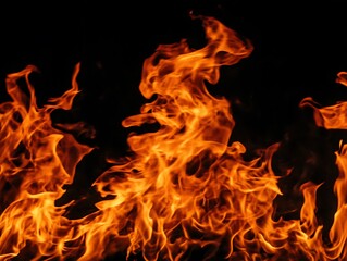 Fototapeta premium Intense bright orange flames burning against a dark black background