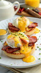 A beautifully plated eggs Benedict featuring a perfectly poached egg sitting atop Canadian bacon and a toasted English muffin, generously drizzled with rich hollandaise sauce