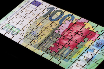 Puzzle pieces of 100 euro and 100 Chinese yuan notes