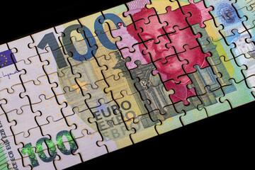 Puzzle pieces of 100 euro and 100 Chinese yuan notes