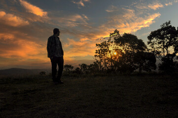 Fototapeta premium silhouette of a man standing on a mountain