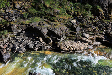 Photo from above overlooking the rocky banks of Abisko Canyon and the fast-flowing river below in Abisko National Park in northern Sweden