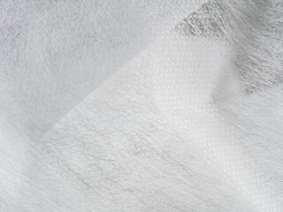 Lightweight, flexible nonwoven fabric. Ideal for various applications. Material properties & textile construction visible.