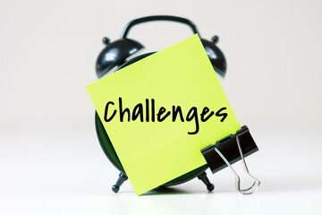 challenges inscription on paper with alarm clock