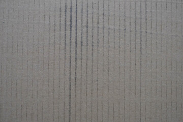 A grey cardboard box with a black line running through it. The box is worn and has a rough texture