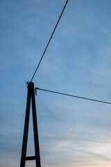 A tall pole with three wires hanging from it