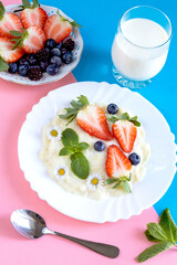 Delicious Breakfast with Semolina Porridge and Berries on a Pink and Blue Background