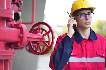 Male engineer inspects water pipelines in the engineering system area of the factory outside where various pipelines are designed modernly. Technicians work in the industry.