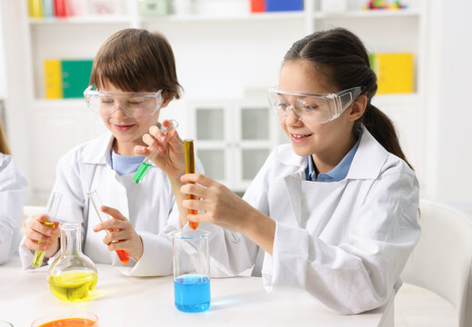 Children doing chemical experiment at desk indoors