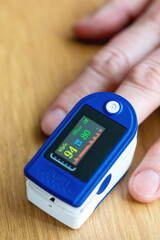 An individual is currently making use of a pulse oximeter on their finger